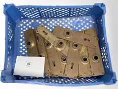 A crate of vintage brass door plates.