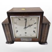 An Art Deco Anvil mantel clock with silvered dial and presentation inscription to front,