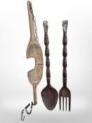 A 19th-century wooden yoke, together with a large carved fork and a spoon, length 90cm.