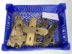A crate of vintage brass door handles and door plates.