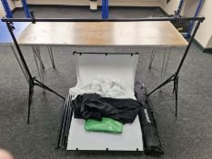 A studio photography set up comprising telescopic tripod stands and backdrops.