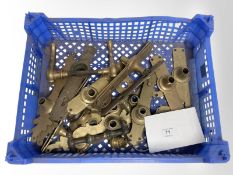 A crate of vintage brass door plates and door handles.