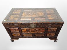 An oriental heavily carved camphor wood blanket chest, with plate glass top,