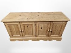 A pine four door low sideboard,