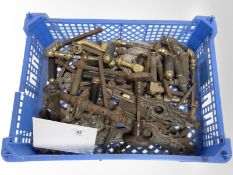 A crate of vintage brass and other door handles and plates.