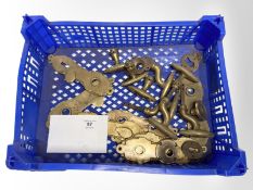 A crate of vintage brass door plates and door handles.