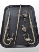 Four oriental white metal pipes and a small scent bottle.