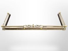 A Victorian brass fire curb