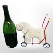 A large green glass bottle, height 75cm, together with a child's push-along soft toy.
