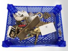 A crate of vintage brass door plates and handles.
