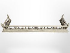 A Victorian brass fire curb,