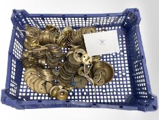 A crate of vintage brass door handle escutcheons.