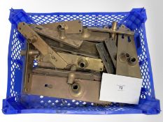 A crate of vintage brass door plates.