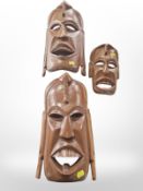 Three contemporary African carved wooden wall masks, largest 40cm long.