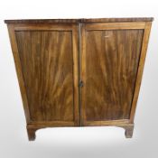 A George III mahogany double-door linen cabinet, 109cm wide x 59cm deep x 115cm high.