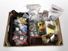 A box containing a large quantity of new fishing equipment including hooks and lines, spool tidies,