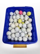 A tub containing a large quantity of golf balls.