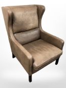 A late 20th century Danish brown leather wing backed armchair,