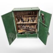 A painted pine tool cabinet containing assorted carpentry tools, chisels, hand saws, Stanley No.