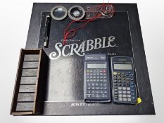 An onyx edition Scrabble game, two calculators, set of Dominoes, compass, laser pen, etc.