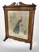 A Victorian mahogany and bead work fire screen depicting a peacock,