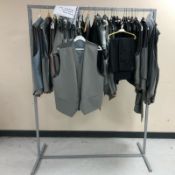 A rail of Gent's waistcoats and black formal striped trousers, various sizes.