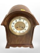 A Victorian walnut domed mantel clock, with enamelled dial, striking on a gong, with pendulum,