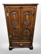 A carved oak double door cupboard,