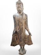 A life-size Thai gilt statue of Buddha standing on lotus plinth, with 'jewelled' decoration,
