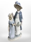 A Nao figure of a mother and daughter, height 37cm, and an Italian figural table lamp.