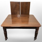 A Victorian-style mahogany extending dining table, with two leaves,