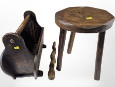 A Yorkshire-style oak tripod stool, together with a magazine rack and a carved rattlesnake.
