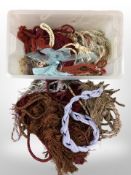 A large quantity of tasselled curtain tiebacks in various colours.