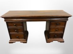 A contemporary hardwood nine drawer twin pedestal desk,