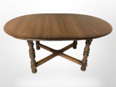 An Ercol elm extending dining table with internal leaf,