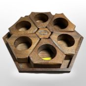 A set of six carved teak napkin rings on hexagonal stand, width 17cm.