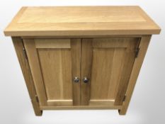 A contemporary oak double door cupboard,