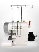 A Singer 14SH754 electric overlock sewing machine with lead and pedal