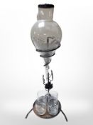 An etched glass decanter and set of four glasses on wrought-metal stand, height 52cm.