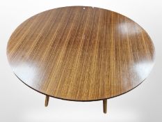 A 1970's G-plan teak circular dining table on laminated bentwood support with splayed legs,