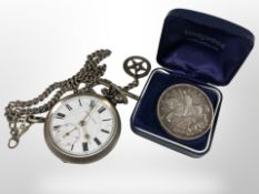 A silver open-faced pocket watch, an Albert chain with silver fob, and a George V 1935 crown.