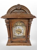 A carved oak eight day bracket clock with brass dial,