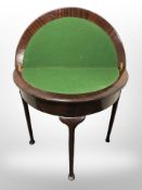 A mahogany demi lune card table on pad feet,