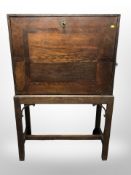 A George III oak fall front secretaire cabinet on stand,