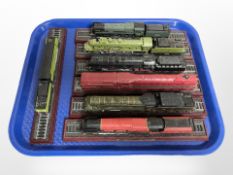 Seven plastic scale model locomotives on plinths.