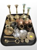 A group of brass candlesticks and chamber sticks, copper wine funnel, pewter candlestick,