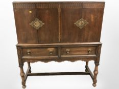 An early 20th century oak four door cabinet,