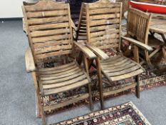 A pair of plantation teak folding armchairs, width 63cm.