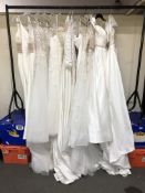 A rail of twelve wedding dresses, sizes 10 - 12,