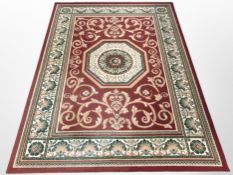 A machine-made rug on red ground, 230cm x 170cm.